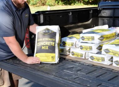 Numerous bags of sakrete in the bed of a truck